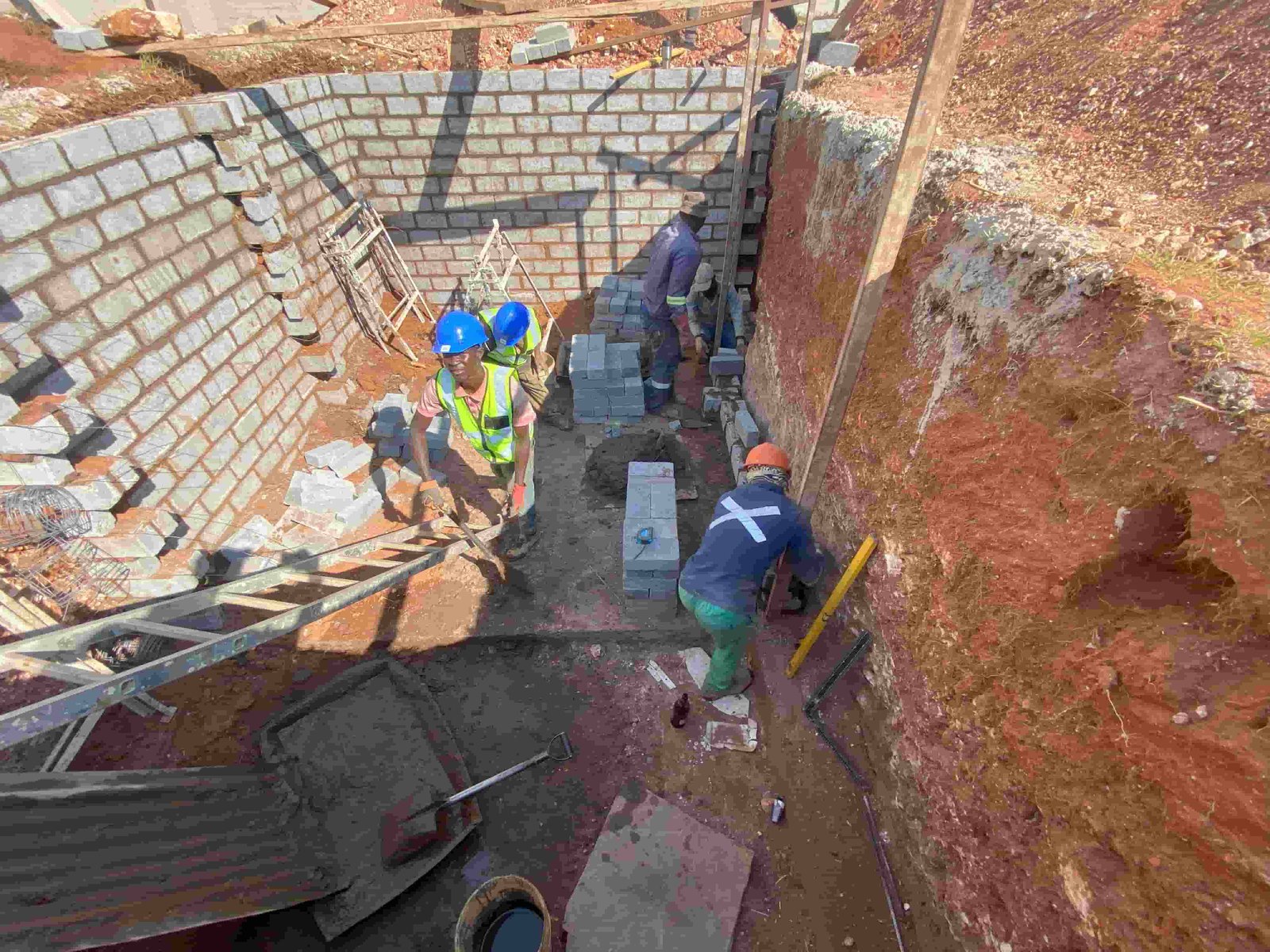 Construction workers from Sikha Construction performing tasks on a house building project